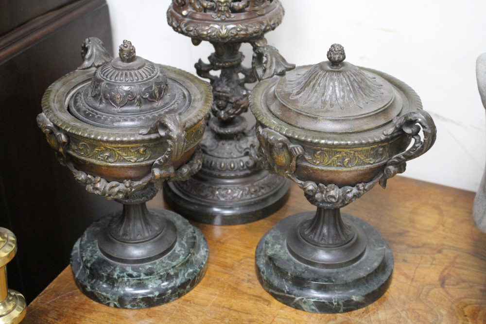 A pair of late Victorian cast iron two handled urns, one with odd lid, an oil lamp base, a pair of cast iron crosses and a pair of bras